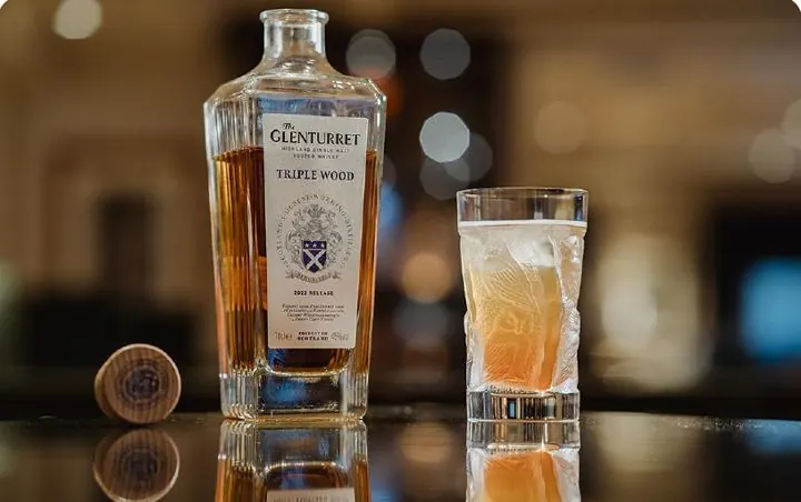 Whisky bottle and cocktail on a bar counter